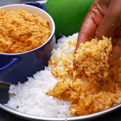 mango chutney in a blue bowl places in a steel plate served with white rice and a green mango for decoration