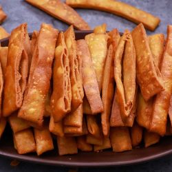 Crispy namak para or namak pare made with moong dal served in a brown bowl