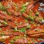 brinjal with garlic chili served in a black dish pot garnished with chopped coriander leaves